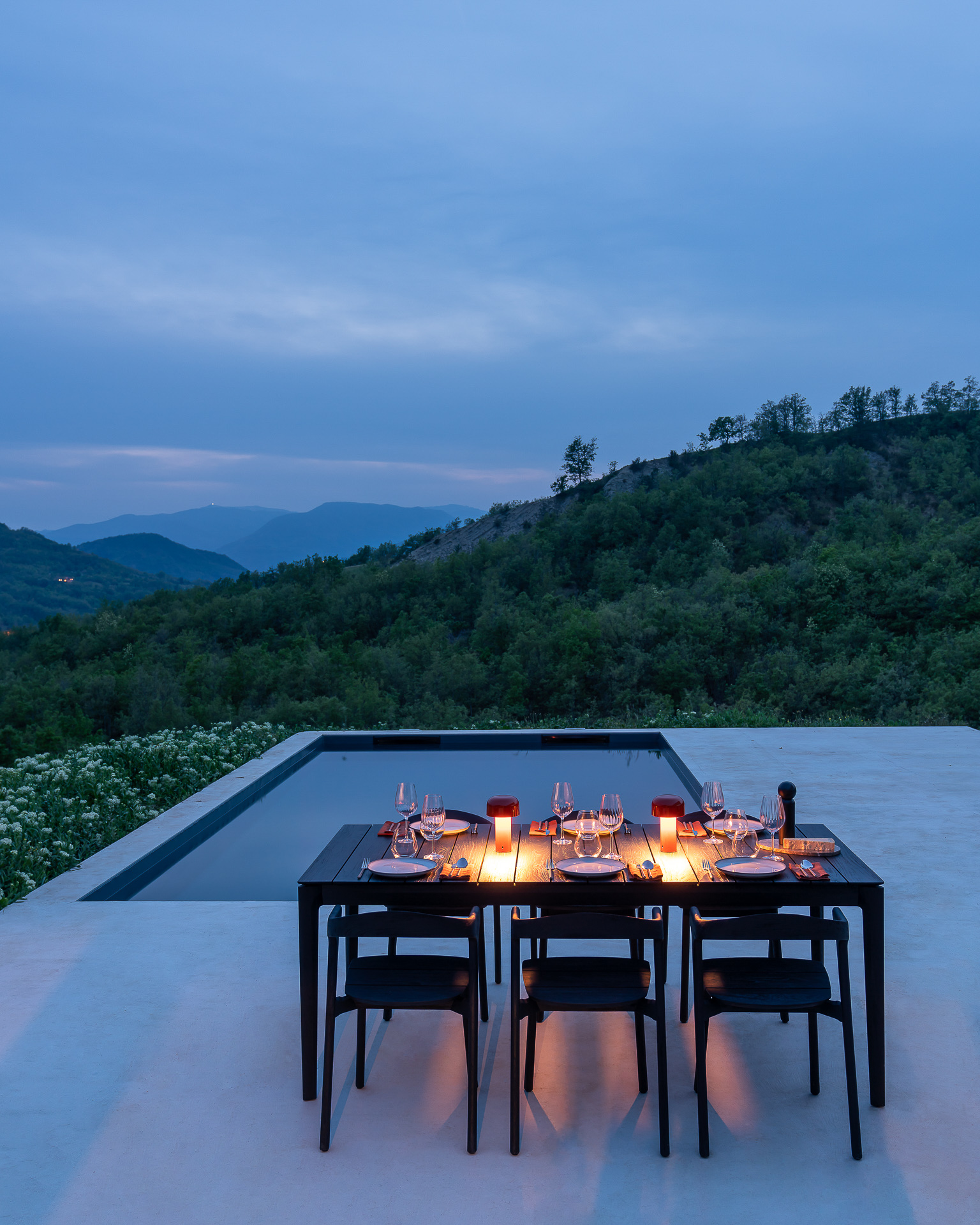 Bild des gedeckten Ethnicraft Tisches Bok in schwarz vor einem Pool.